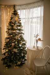 Designer Christmas tree decoration with lights. Concept for New Year and Christmas celebrations. Gifts in artisanal packaging under the tree.