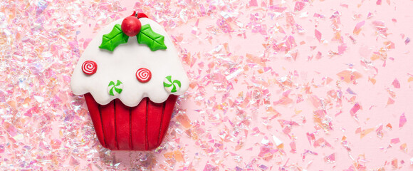 Vintage Plasticine clay cupcake on pink glitter background. Minimal Christmas concept. Happy New...