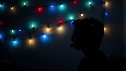 Cozy gaming setup christmas silhouette of a man in front of colorful string lights at night