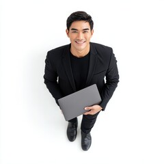 A smiling man in a black suit holding a laptop from above, standing on a white background.