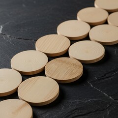 Wooden coasters arrangement on a dark textured surface for product staging