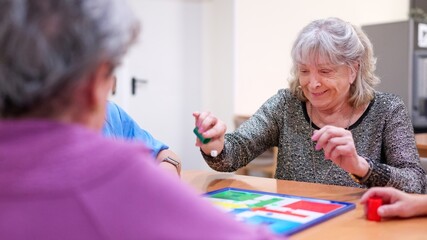 Elderly women playing board game in nursing home