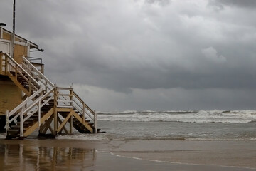 Winter storm Byron on the Mediterranean coast of Tel Aviv. A lifeguard station and waves crashing on a sandy beach