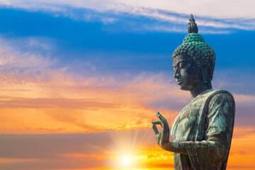 large Buddha statue, built according to Buddhist beliefs, stands against a clear blue sky and clouds