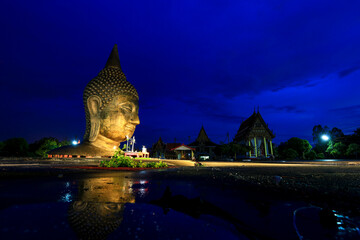 A large Buddha head stands prominently at Wat U Ya in Suphan Buri Province, Thailand. © Somsak