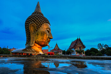 A large Buddha head stands prominently at Wat U Ya in Suphan Buri Province, Thailand. © Somsak