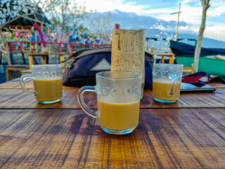 Three Glass Mugs of Coffee on Rustic Wooden Table Outdoors with Scenic