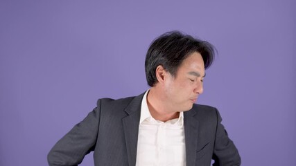 Middle Aged Businessman Rubbing Sore Shoulder Against Purple Background