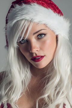 xmas dress of blonde girl wearing santa claus jat in studio, celebrate, christmas, christian, x-mas, noel, nativity, holiday, portrait format, photorealistic