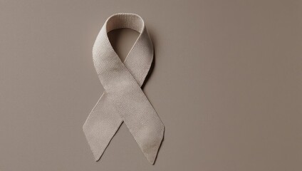 Beige awareness ribbon on neutral background