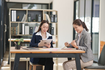 Asian businesswoman at work using laptop talking and consulting in office	