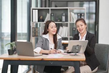 Asian businesswoman sitting at work using laptop talking and consulting in office