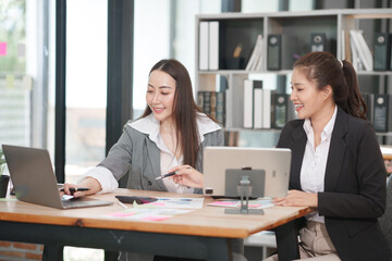 Asian businesswoman sitting at work using laptop talking and consulting in office	
