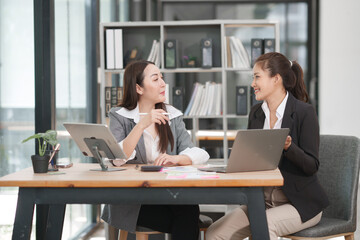 Asian businesswoman at work using laptop talking and consulting in office	
