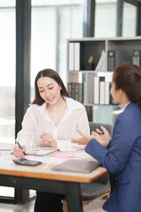 Asian businesswoman sitting at work using laptop talking and consulting in office