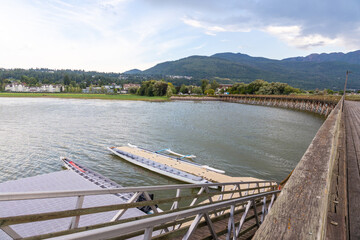 Obraz premium Dragon boats floating near wooden pier in salmon arm, british columbia