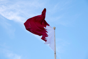 Doha, Qatar- December 10, 2025: Qatar Flag flying high in the wind. National Museum Qatar 