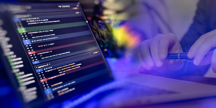 Close-up of a developer reviewing Python code on a laptop during a meeting, symbolizing teamwork, software development, and debugging. - Powered by Adobe