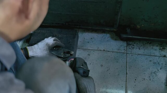 A skilled worker expertly grinds a metal surface using an angle grinder tool generating a shower of orange sparks 