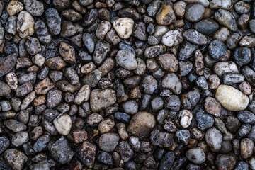 Close-up view of small gravel stones filling the entire frame. Natural rocky texture suitable for backgrounds, surfaces, design projects, and construction-related concepts.