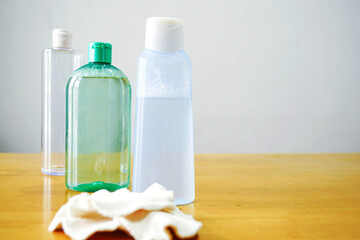 Three skincare bottles in different sizes next to reusable makeup remover pads. Illustrates eco-friendly alternatives to disposable products, layered beauty routine, and personal care sustainability.