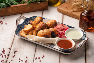 Grilled champignon mushroom skewers served with potato wedges pickled onions and dipping sauces on a rustic plate