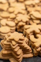 Baked gingerbread cookies lying on top of each other side by side.
