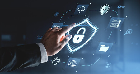 Businessman hand touching digital lock icon hologram on futuristic interface with cybersecurity concept symbols on a blue technology background.