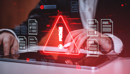 Data security breach warning with digital alert symbol on touchscreen device surrounded by document icons and hacker threat concept background.