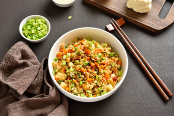 Asian style cauliflower fried rice with carrot, green pea, corn, scrambled eggs in bowl