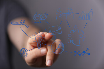 Close-up hand interacting with a business plan graphic with an lightbulb and search icon representing business strategy and innovation.