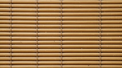A realistic woven bamboo mat texture background with fine parallel strips and warm honey color