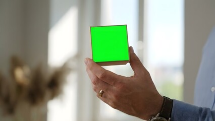 Person Holding Green Cube in Hand Indoor.