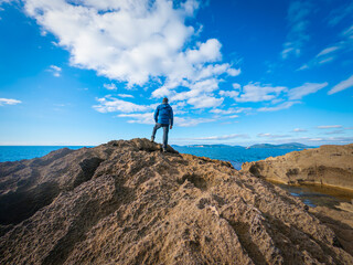 Man watching the sea on a rocky shore