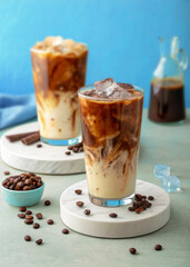 Iced Coffee with Milk and Ice Cubes in Glass on Minimal Background