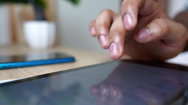 Close-up of Tablet Use with Smartphone Nearby