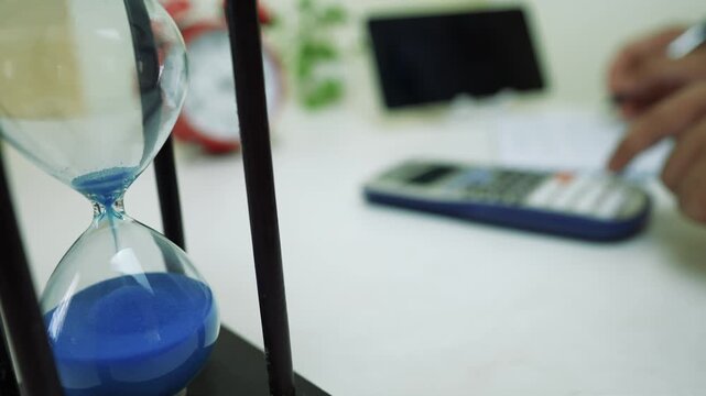 Hourglass and Calculator in Business Setting
