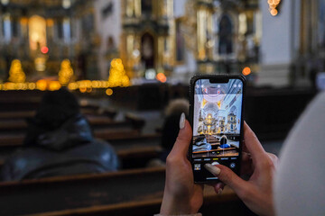 Belarus, Misk, 03.01.2024 Woman holding smartphone with AR church overlay in ornate interior....
