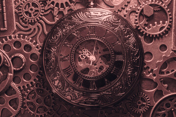 Copper antique pocket fob watch with gears and cogs in the background. Vintage industrial steampunk fashion accessories.