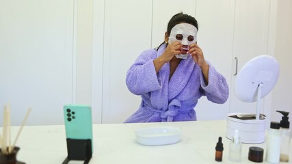 Influencer wearing a bathrobe applying a beauty face mask