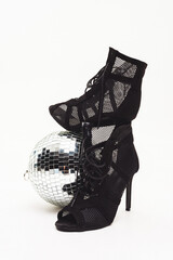 Dancing shoes placed near a disco ball in a well-lit area for a lively event at night