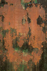 Detail of green and black flaking paint on old rusty metal board