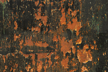 Detail of rusty metal sheet with scraps of flaking black paint