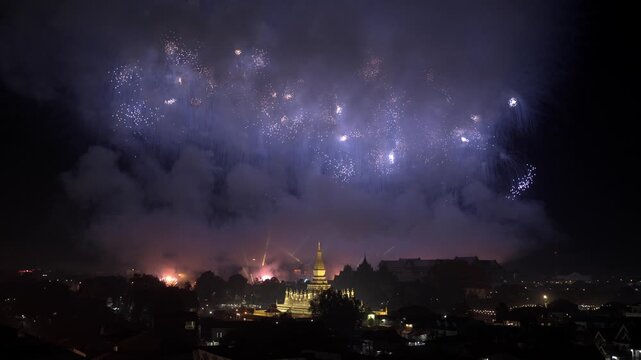 Multi-Color Firework Bursting Above Vientiane's Golden Pha That Luang Stupa at Night during National Celebration