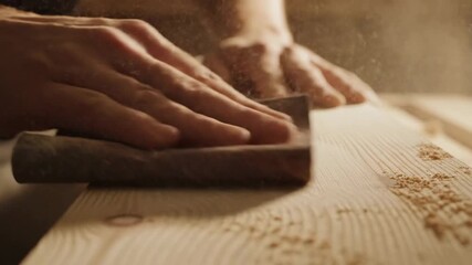 Carpenter smoothly sanding wood plank in workshop with expertise and precision