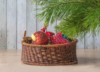 Merry Christmas greeting card; Vintage basket with christmas decoration, pine branch on a wooden background