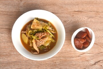 spicy boiled tilapia fish with mixed vegetable in curry soup Thai food in bowl and fried sweet Chinese sausage 