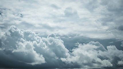 Obraz premium Cloudy sky background with thick, fluffy clouds in varying shades of blue, gray and white