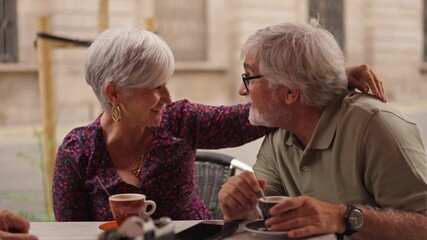 Affectionate senior couple enjoying coffee together at cafe - Powered by Adobe