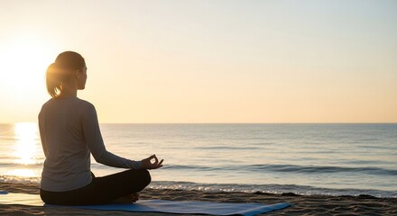 Woman meditating on beach at sunrise